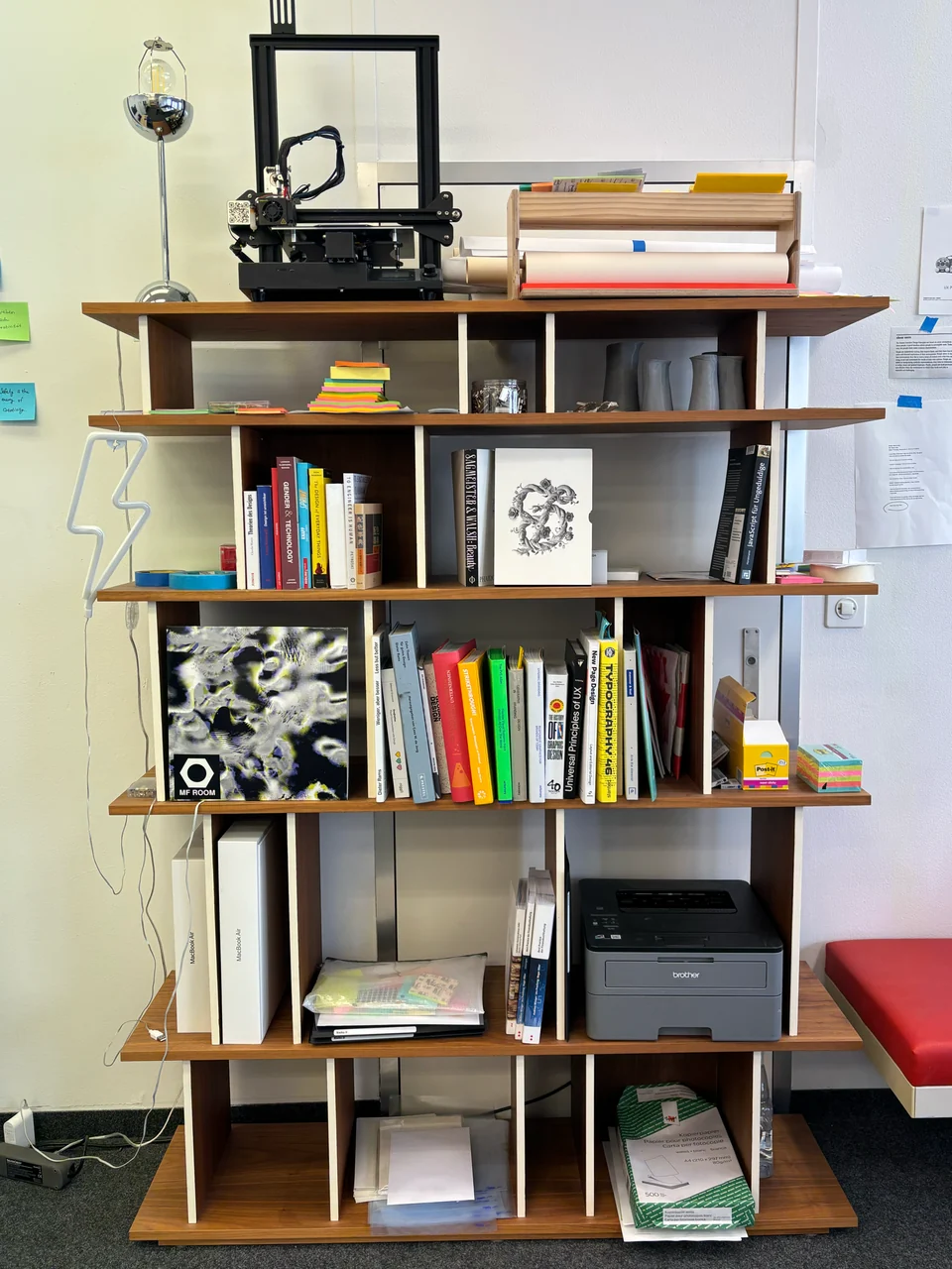 Books and studio equipment on a wooden shelf