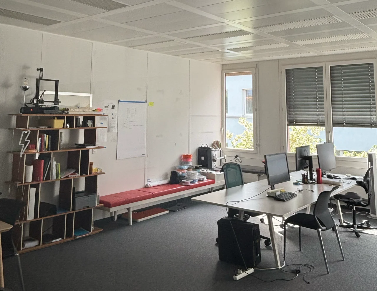 Studio desks, bookshelves and a red bench