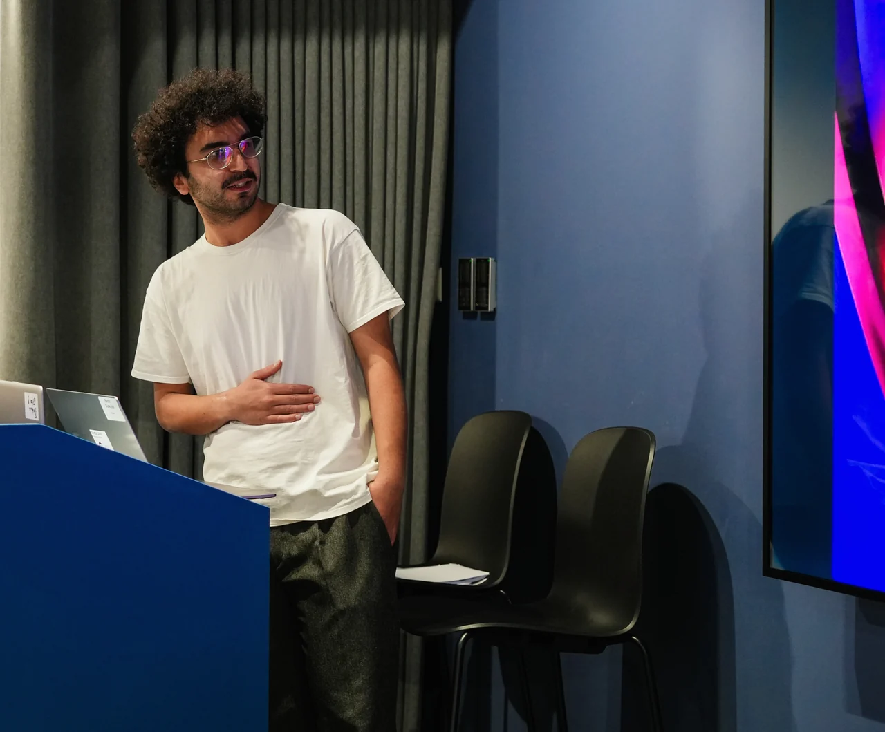 A colleague presenting beside a large screen