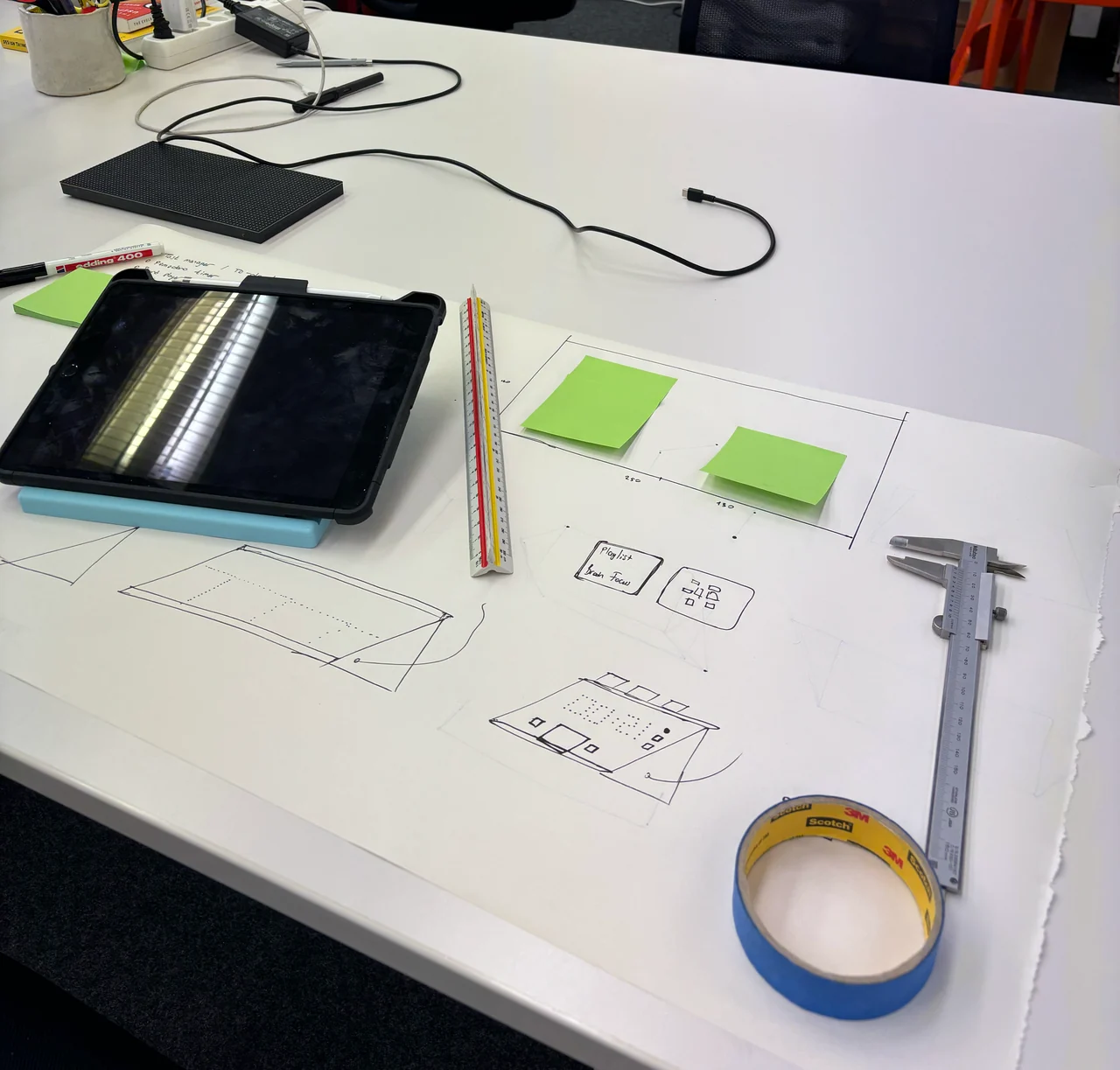 Sketches, sticky notes and a tablet on the workbench